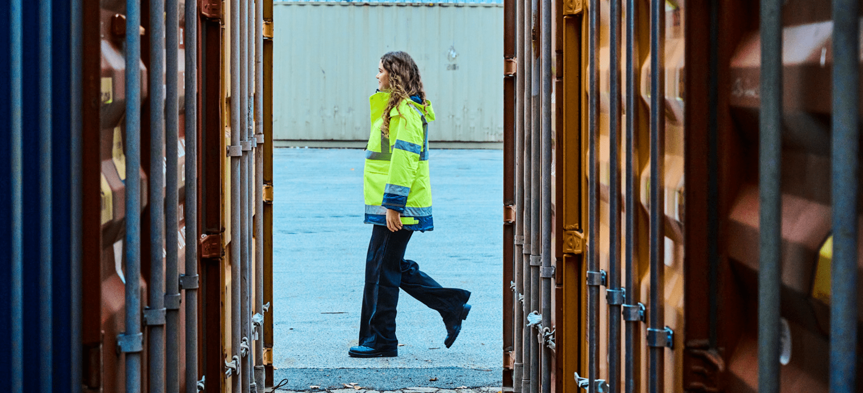 une femme marchant entre les conteuneurs